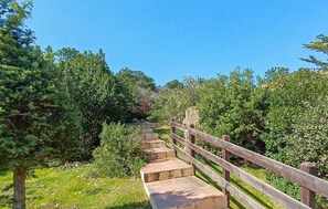 A wooden staircase leading up a hill, surrounded by greenery and trees. - Amazing apartment in Costa Paradiso with swimming pool (Costa Paradiso)