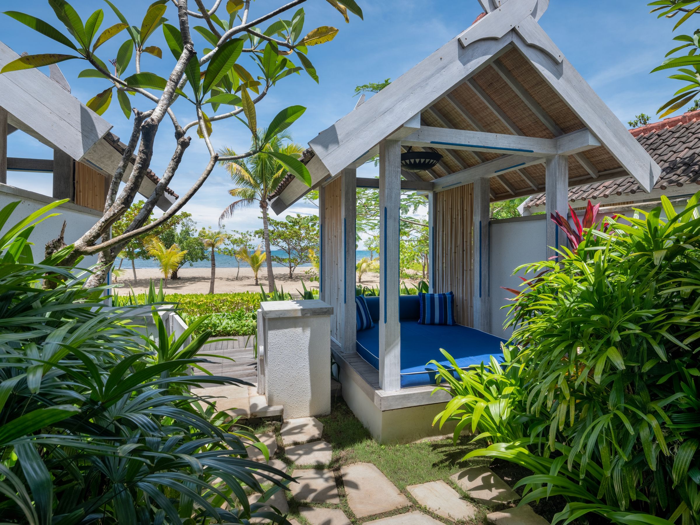 A covered outdoor seating area with a view of the beach.