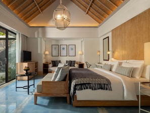 A modern bedroom with a large bed, a TV, and a dining area with a table and chairs. - Sudamala Resort, Komodo, Labuan Bajo (LABUAN BAJO)