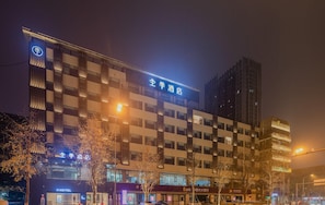A hotel building with multiple floors, illuminated signage, and a modern architectural design. - Ji Hotel (Chengdu)