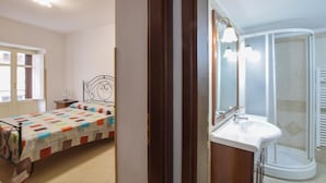 Une chambre à coucher avec un lit, une table de chevet et une fenêtre.