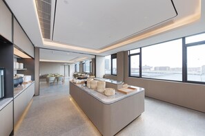 A modern hotel lobby with a central reception desk, seating area, and large windows offering city views. - Ji Hotel (shaoxing Shangyu Economic Development Zo (Shaoxing)