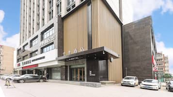 Un hotel con fachada moderna, amplias ventanas y una entrada destacada.
