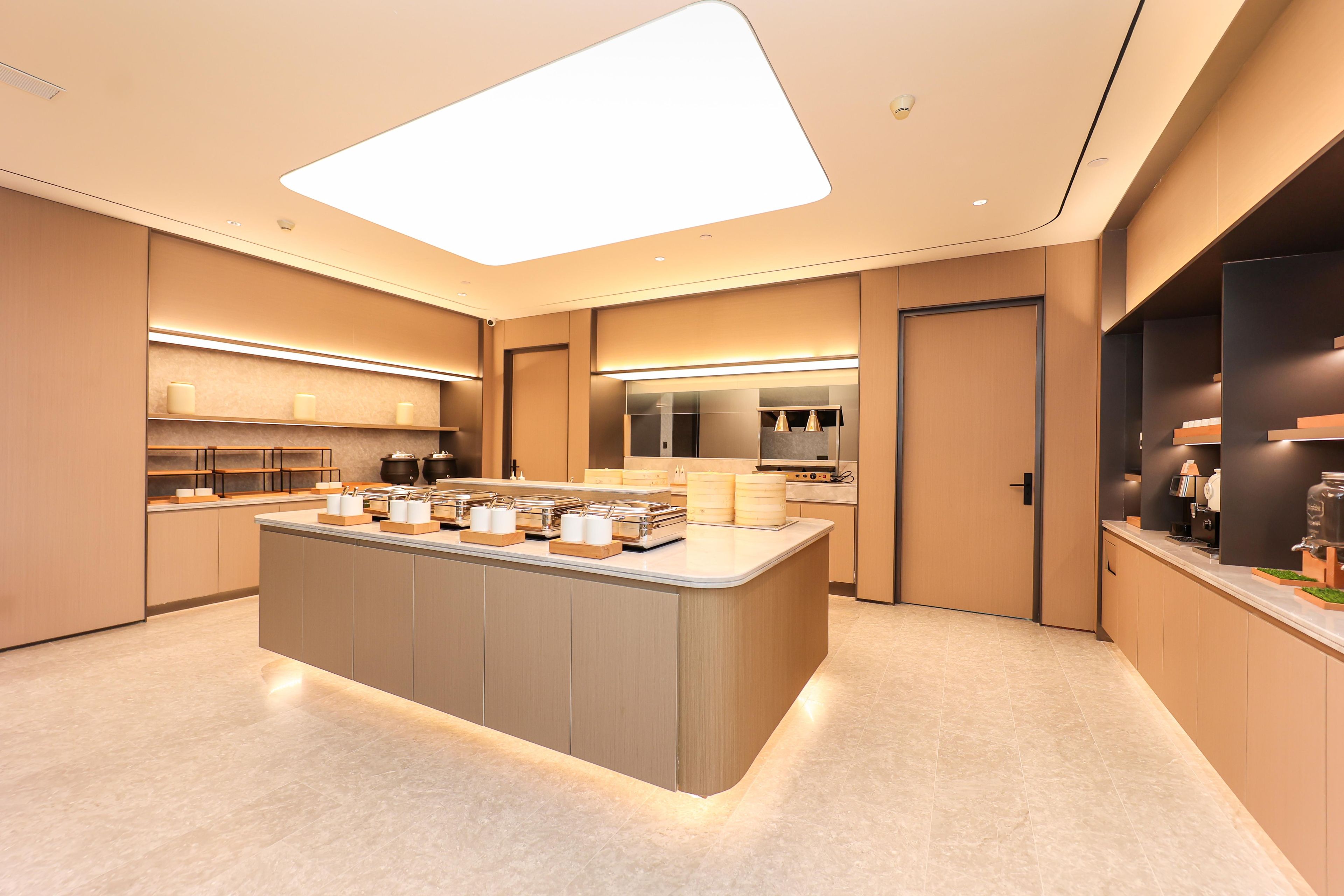 A modern kitchen with a central island, built-in appliances, and a large skylight.