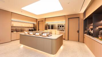 A modern kitchen with a central island, built-in appliances, and a large skylight.