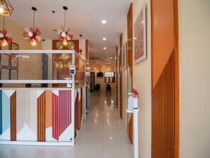A hotel reception area with a modern design, including a reception desk, wall-mounted clocks, and decorative lighting. - OYO 832 The Teepee Place Hostel & Residence Inn (Cebu City)