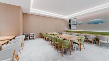 Ein moderner Konferenzraum mit einem langen Tisch, Stühlen und einem großen Fenster.