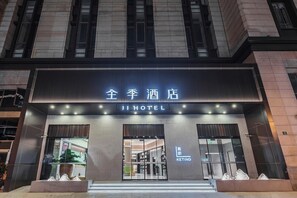 A hotel entrance with a sign reading 'JI HOTEL' and a visible entrance door.