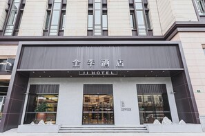 A hotel facade with large windows, a modern design, and a sign indicating it is a hotel.
