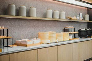 A kitchen counter with storage containers, wooden boxes, and a stove.