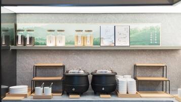 A buffet setup with jars of grains, a menu board, and two large cooking pots.