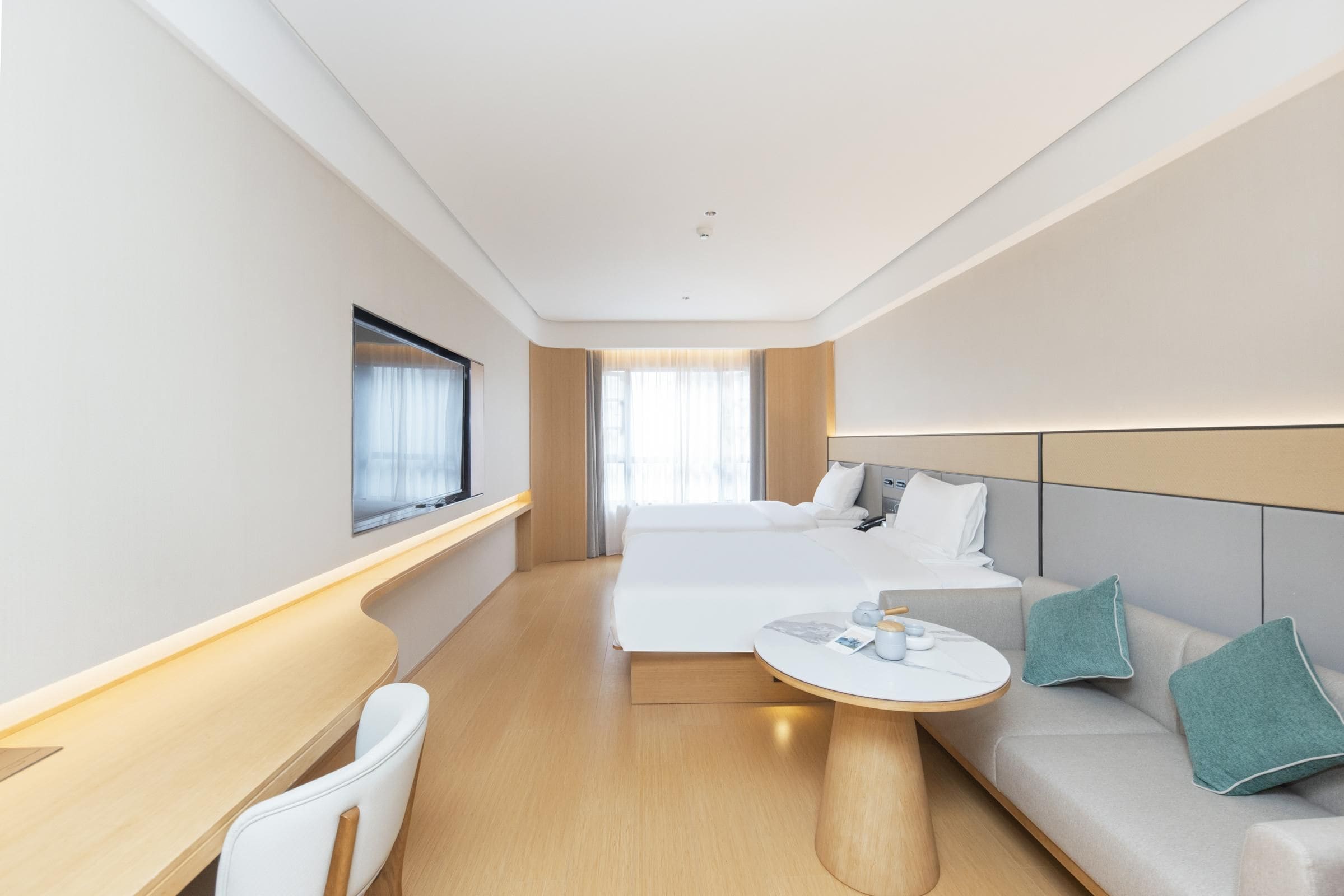Una moderna camera d'albergo con un letto, un divano, una scrivania e un tavolino.