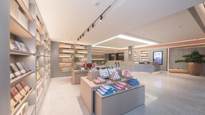 A modern library interior with bookshelves, a reception desk, and a large potted plant. - Ji Hotel (Ningbo)