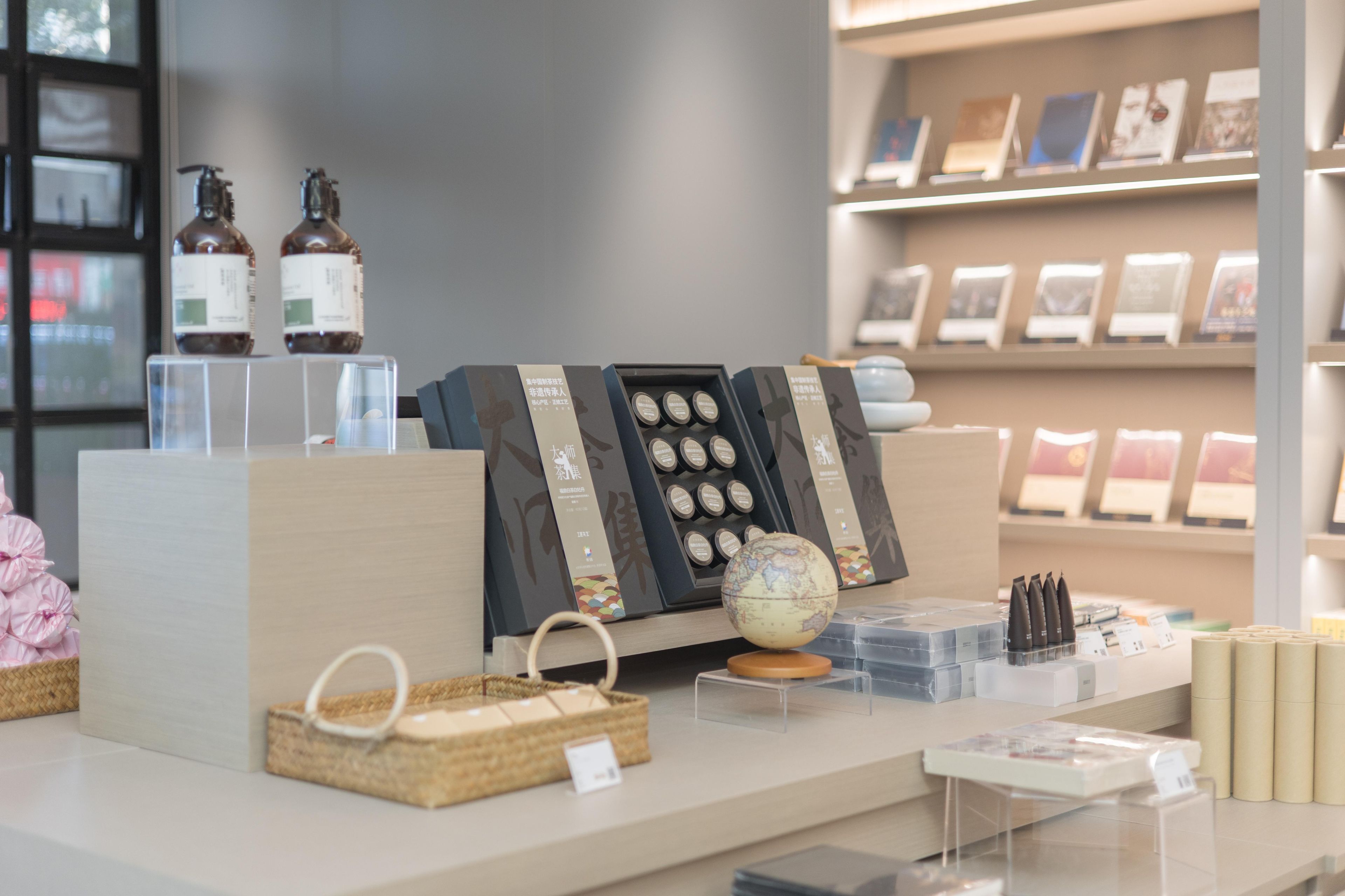 A display of various items including bottles, a globe, and boxes on a counter.