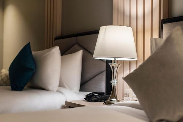A hotel room with a bed, a bedside lamp, a telephone, and a nightstand. - Enala Tabuk Hotel (Tabuk)
