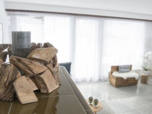 A modern living room with a glass table, wooden blocks, and a glass vase. - Canols für 6 Personen Valbella-Lenzerheide by Interhome (Valbella)