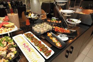 Un buffet proposant une variété de plats, notamment des salades, des fruits de mer et des hors-d'œuvre.