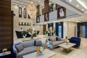 A hotel lobby with sofas, a reception desk, a chandelier, and a large portrait on the wall. - Elian Alsahafa Tower Hotel (Riyadh)