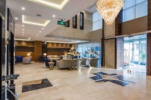 A spacious lobby with a chandelier, seating area, and a reception desk. - Elian Alsahafa Tower Hotel (Riyadh)