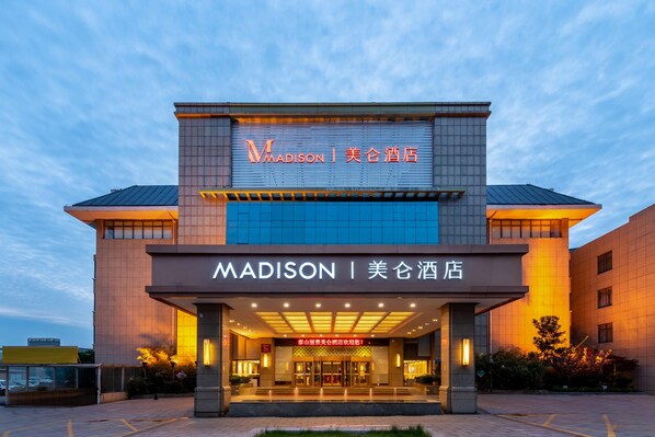 A hotel with a modern facade, illuminated signage, and a welcoming entrance.