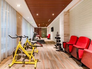 A gym with exercise bikes, treadmills, and red chairs. - Madison Hotel Tai Mountain Scenic Spot (Tai'an)