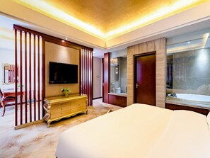 A hotel room with a large bed, a television mounted on the wall, a wooden dresser, and a bathroom with a bathtub and mirror. - Madison Hotel Tai Mountain Scenic Spot (Tai'an)