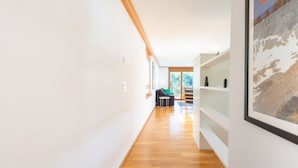 A modern interior with a wooden floor, white walls, and a staircase leading to a balcony. - Casa Miro Nr. 7 by Interhome (Flims)