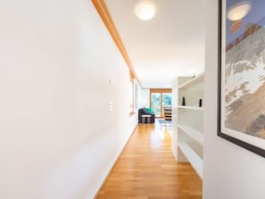 Een modern interieur met een houten vloer, witte wanden en een trap naar een balkon.