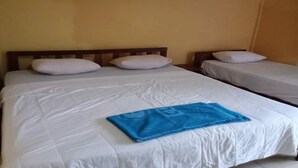 A hotel room with two beds, white bedding, and a blue towel on the larger bed. - OYO 91230 Kelimutu Eco Village (Moni)