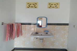 A bathroom with a sink, mirror, and two ventilation grilles on the wall. - OYO 91230 Kelimutu Eco Village (Moni)