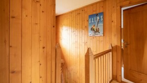 Un interior de madera con una escalera, una puerta y un cartel en la pared.