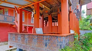 A traditional building with a covered porch, a staircase, and a decorative tiled wall.