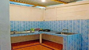 A kitchen with blue patterned tiles, a sink, and a stove.