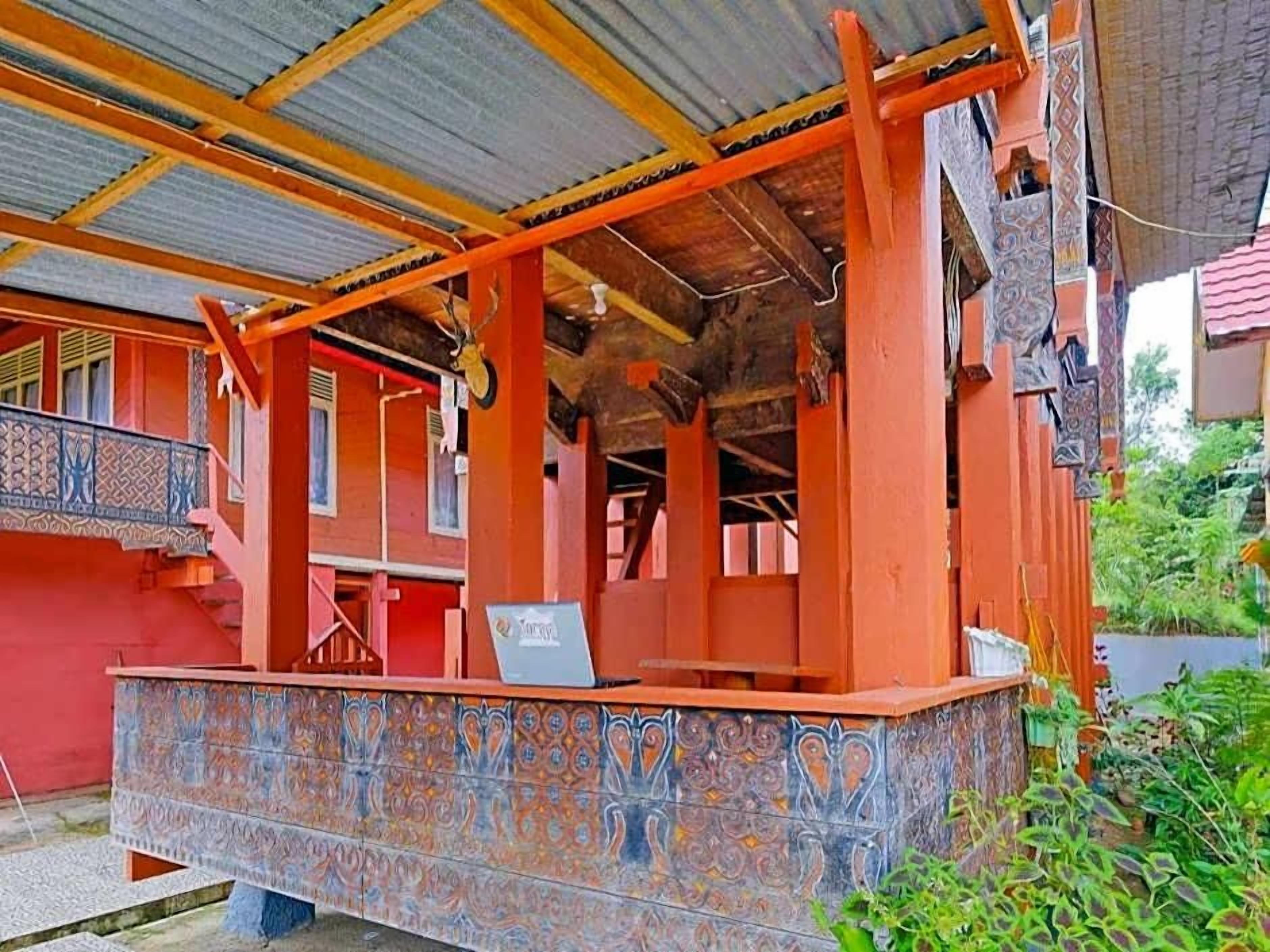 A traditional building with a covered porch, a staircase, and a decorative tiled wall.