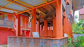 A traditional building with a covered porch, a staircase, and a decorative tiled wall.
