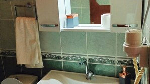 A bathroom with a sink, toilet, and a mirror above the sink. - Canario Bungalows (Kemer)