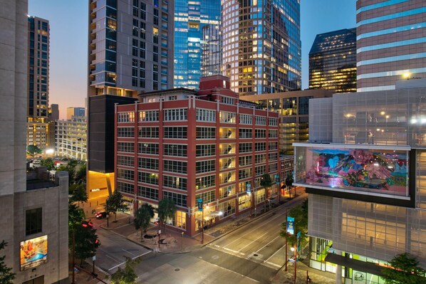 A multi-story building with a red facade, large windows, and a flat roof. - Reside Houston Downtown A Wyndham Residence (Houston)