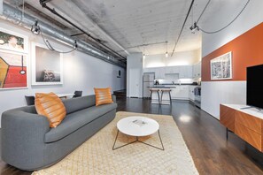 Una sala moderna con un sofá, una mesa de centro y obras de arte en las paredes.