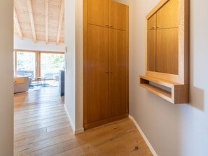 A hallway with wooden flooring, a wooden wardrobe, and a wooden shelf. - Casa Miraselva 1.7 by Interhome (Flims)