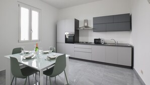 Eine moderne Küche mit weißen Schränken, einem Gasherd, einem Backofen und einer Mikrowelle.