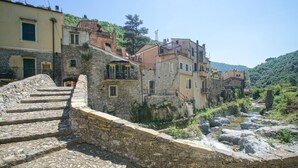 Eine Steintreppe führt zu einer Steinmauer mit Blick auf einen Fluss.