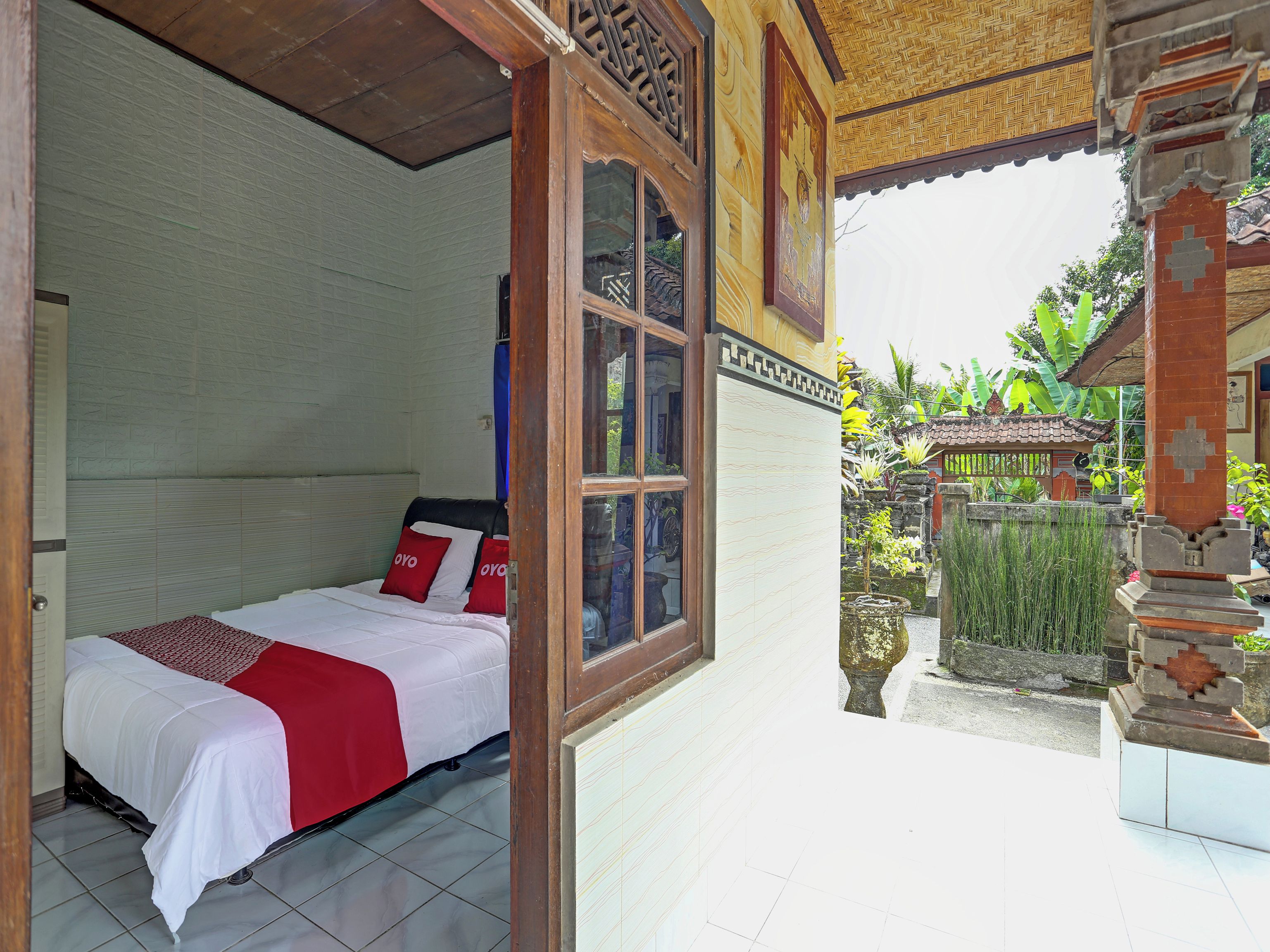 A room with a bed, a window, and a view of a garden.