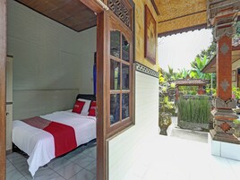 Quarto com cama, janela e vista para um jardim.