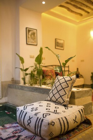 A room with a bed, a small pool, and potted plants. - Riad Mama Square (Marrakech)