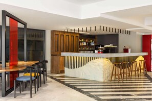 A modern kitchen with a bar area, wooden cabinets, and a striped floor. - Ramada Encore by Wyndham Istanbul Arnavutkoy (Istanbul)