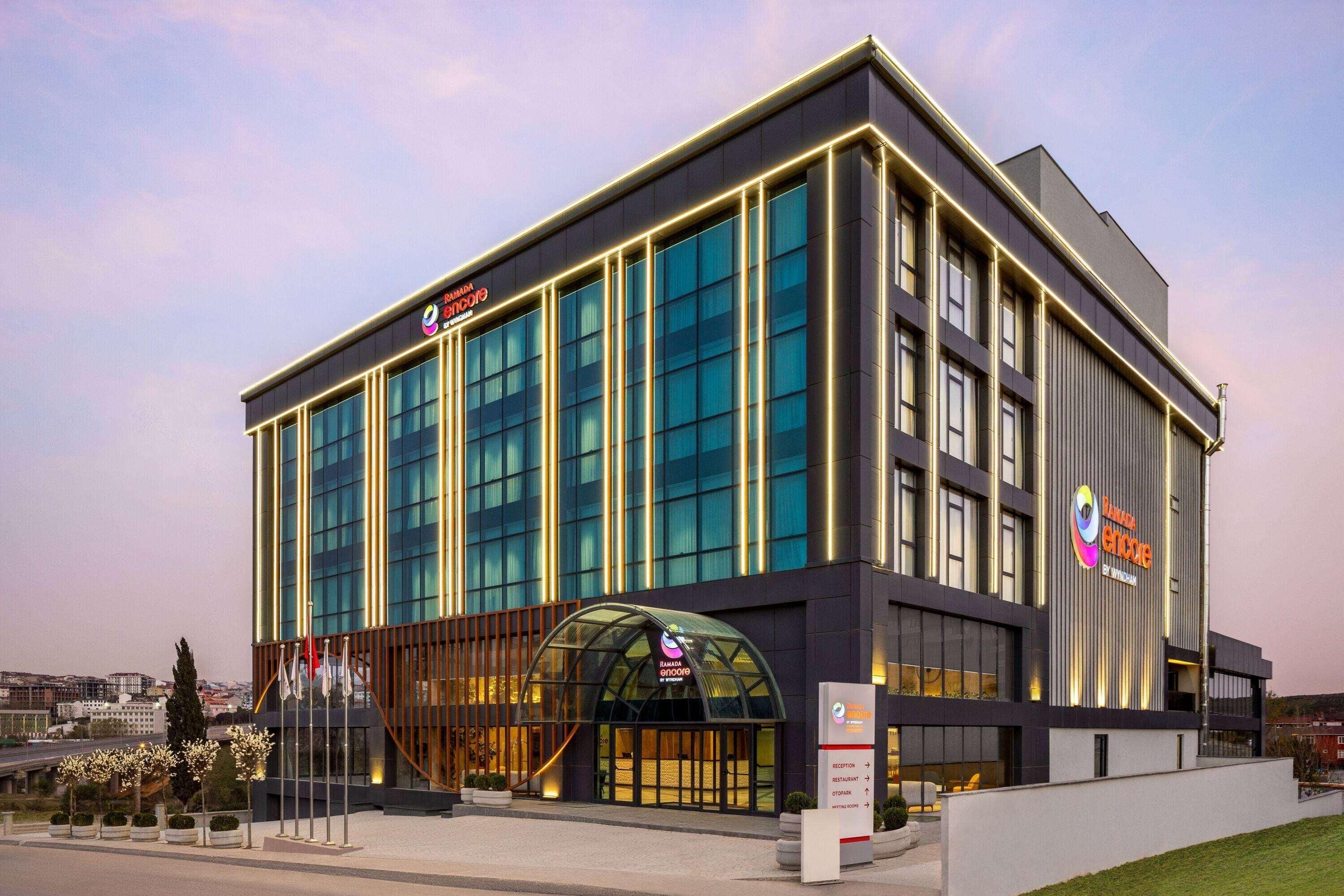 A modern hotel with a glass facade, a prominent entrance with a curved roof, and a sign indicating it is a Marriott hotel.