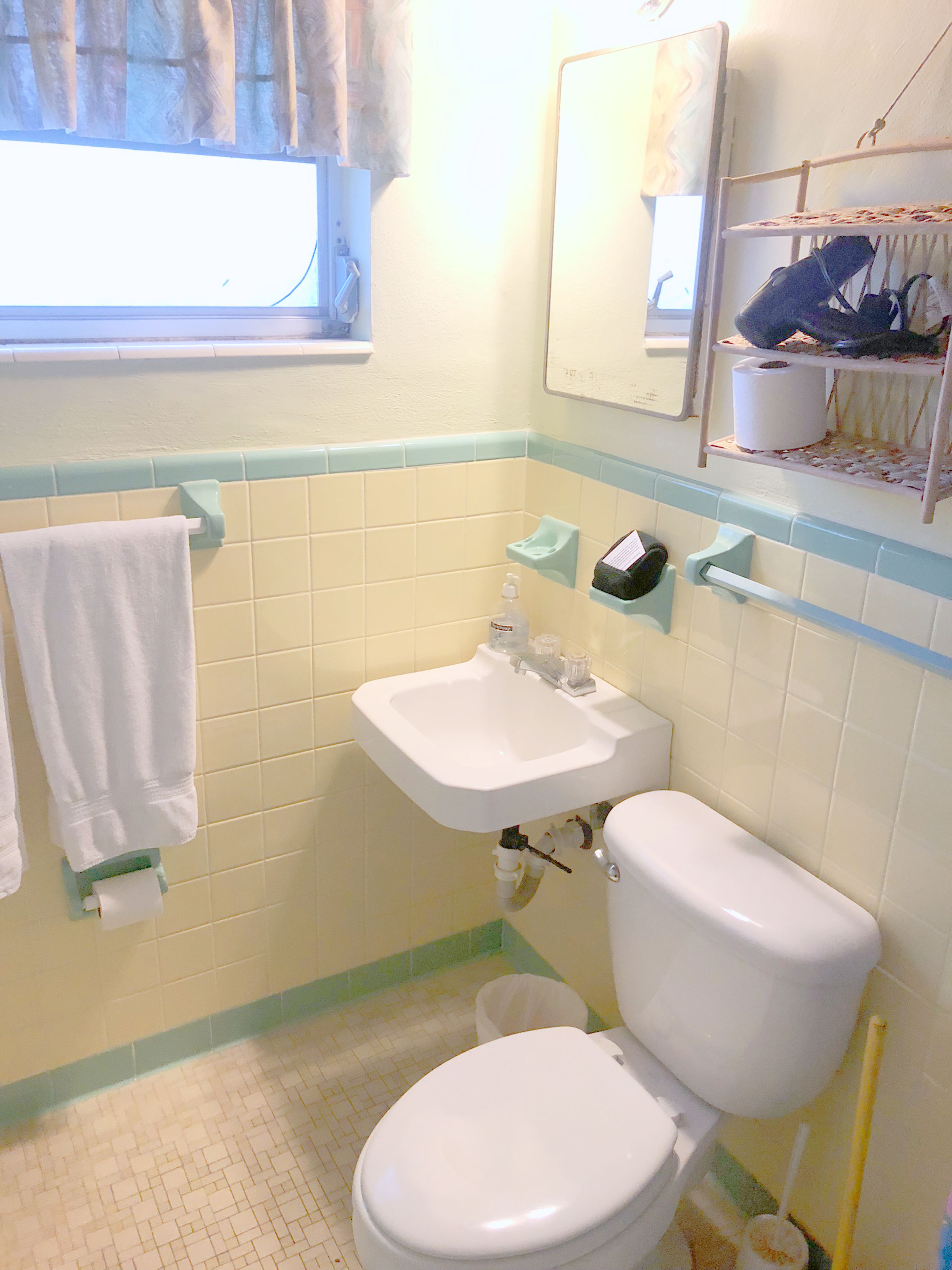 A bathroom with a toilet, sink, and towel rack.