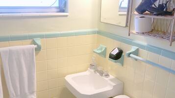 A bathroom with a toilet, sink, and towel rack.