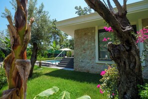 A house with a stone exterior, a swimming pool, and a well-maintained lawn. - Silyan Villas (Konyaalti)