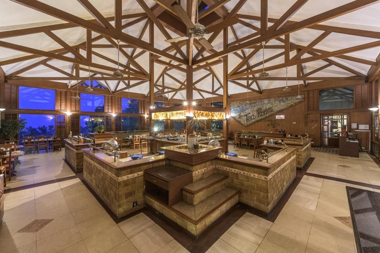 Ruime bar met hoge plafonds en houten balken, voorzien van meerdere toogbladen en zitplaatsen.